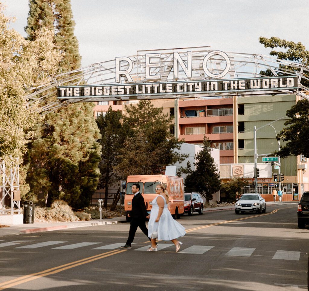 husband and wife walk under the old Reno, Nevada sign