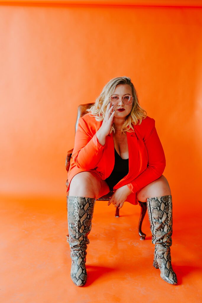 woman sits in a chair in snakeskin boots