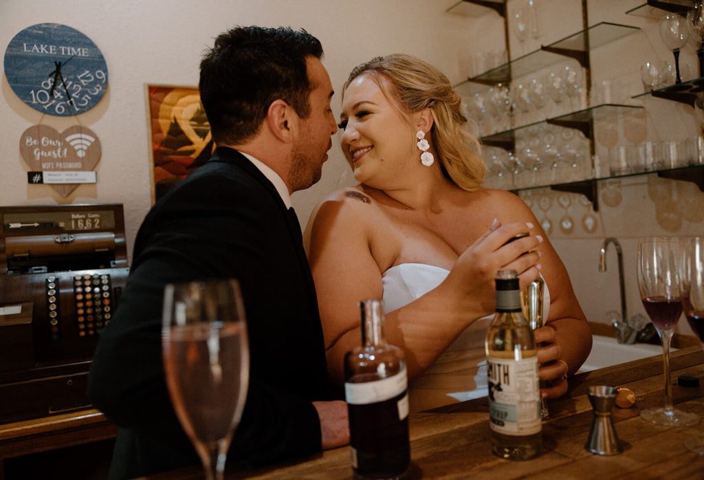 the bride and groom make cocktails after the elopement at their airbnb venue