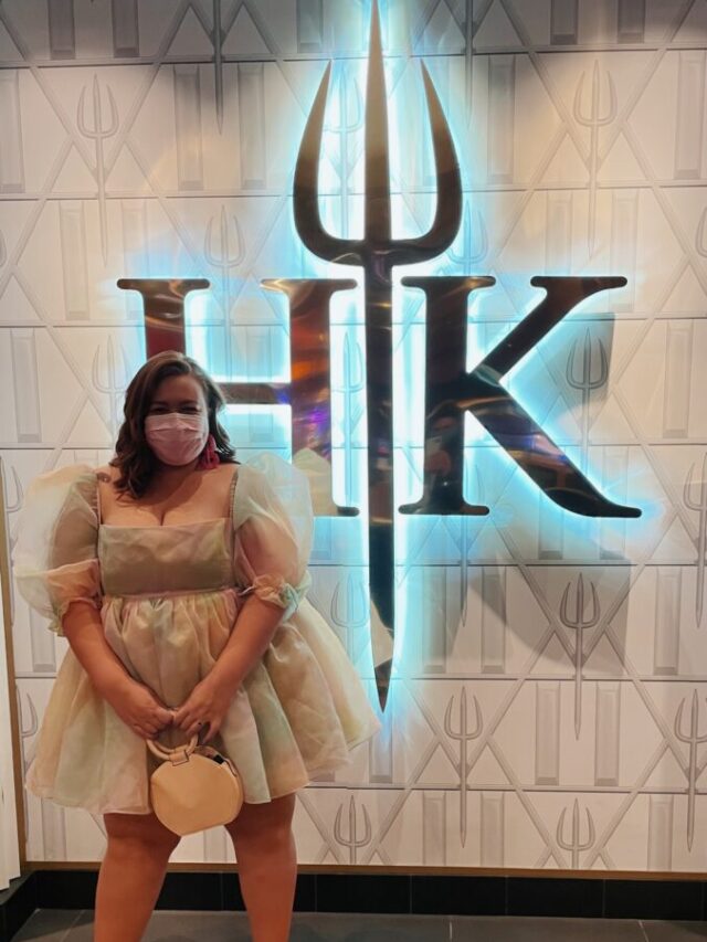 gabbi stands in front of the hells kitchen sign