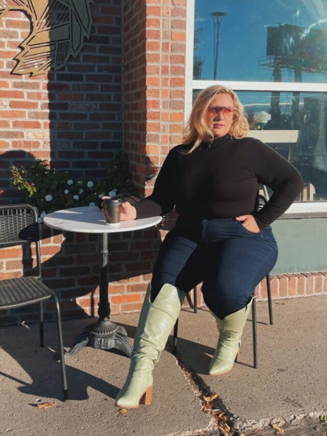 woman sits in green wide calf boots at a coffee table